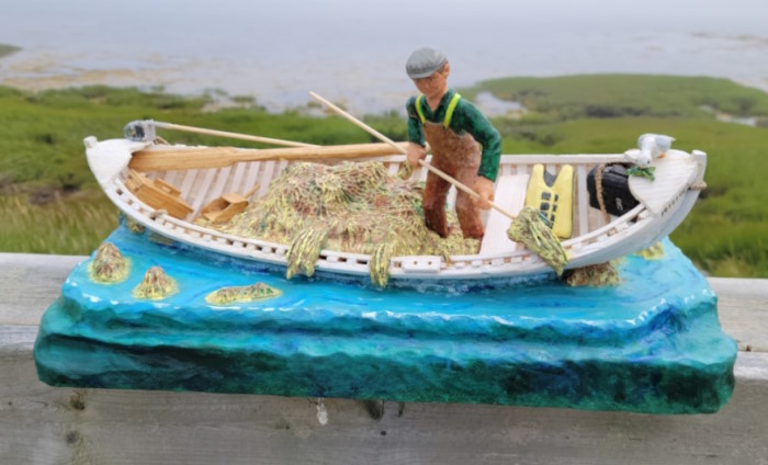 A fisherman is harvesting seaweed in his skiff.